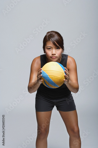Young woman with volleyball smiling at camera