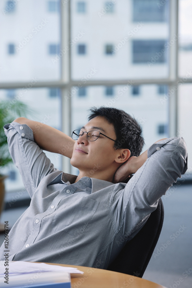 A man relaxes at his desk