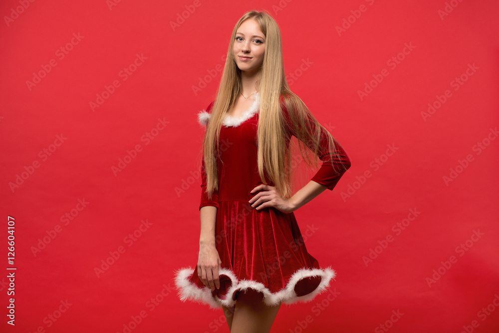 beautiful girl dressed in santa claus over a red background beautiful girl dressed in santa claus over a red background