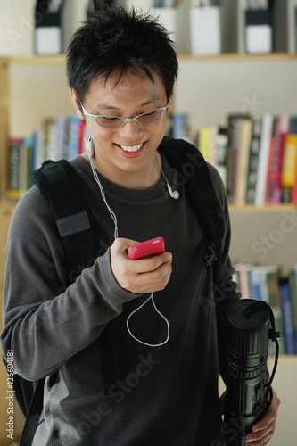 A young man listens to music in the library