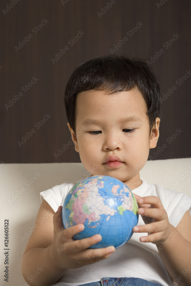 Baby boy looking at globe Baby boy looking at globe