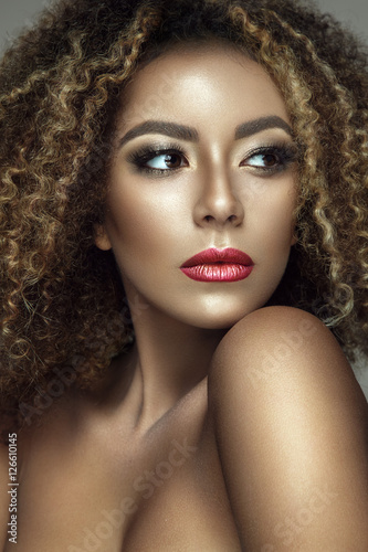 Beautiful portrait of afro woman. Young lady posing close up with colorful make up and curly hair.