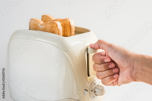 Woman hand using a toaster on white background