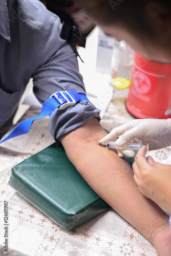 Nurse taking a blood sample for test the health © teerasaksombun