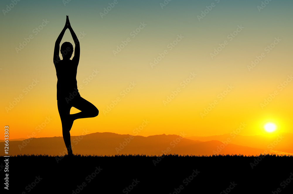 woman in a meditating yoga pose overlooking the beautiful sunset