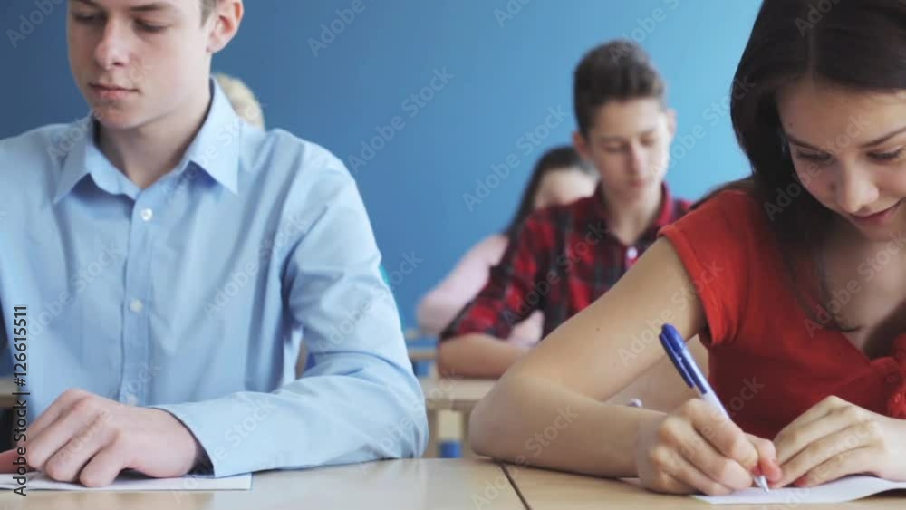 students with notebooks writing test at school students with notebooks writing test at school