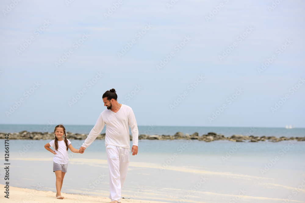 Father and daughter walking on deserted tropical beach together happy loving vacation Father and daughter walking on deserted tropical beach together happy loving vacation