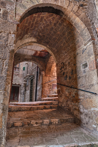 Sorano  Grosseto  Tuscany  Italy  old narrow alley with dark underpass in the medieval town   