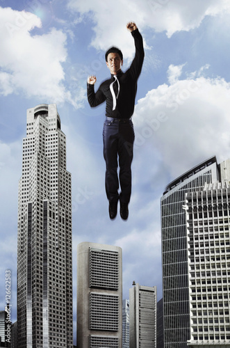 Man flying in the sky over buildings