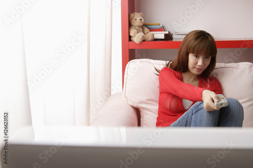 Asian girl watching TV in her bedroom