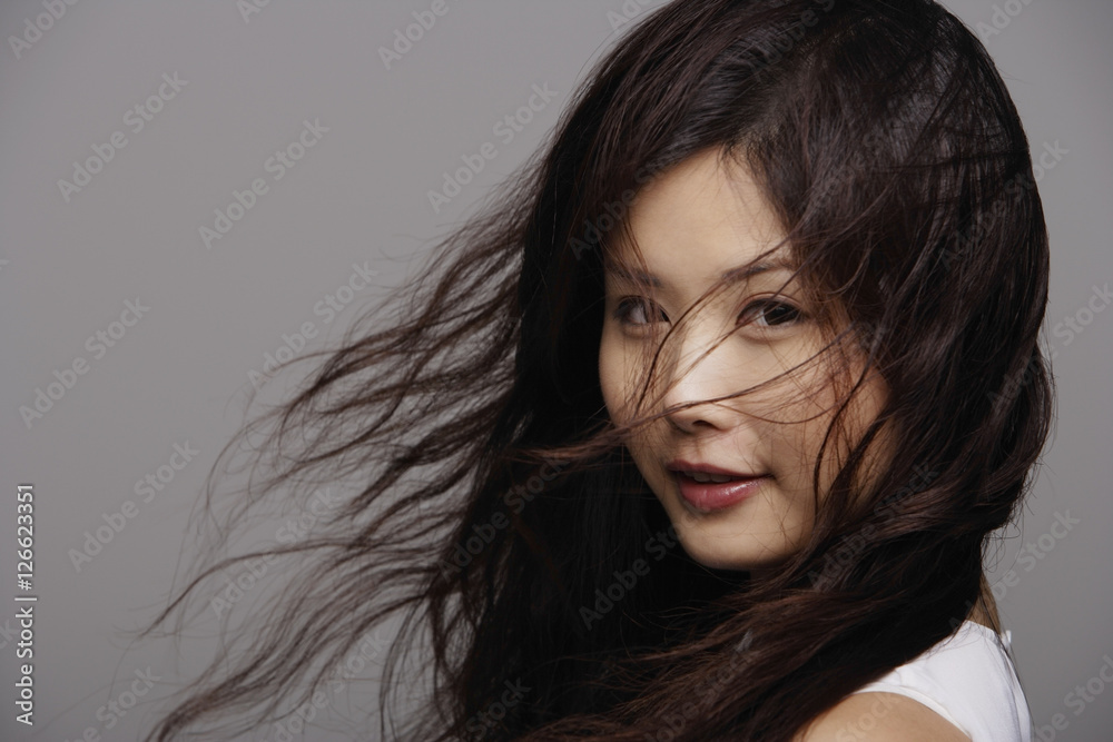 Head shot of Chinese woman with wind blown hair Head shot of Chinese woman with wind blown hair