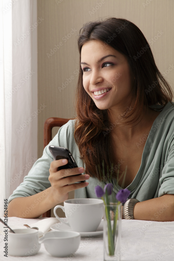 young woman texting on phone a cafe