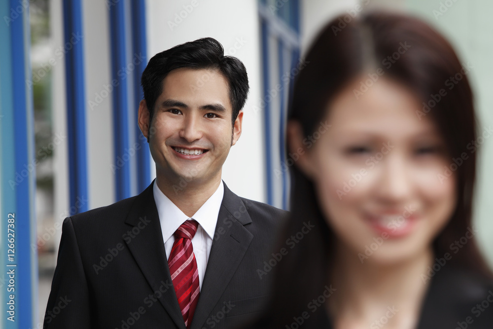 man smiling with woman in out of focus in foreground man smiling with woman in out of focus in foreground
