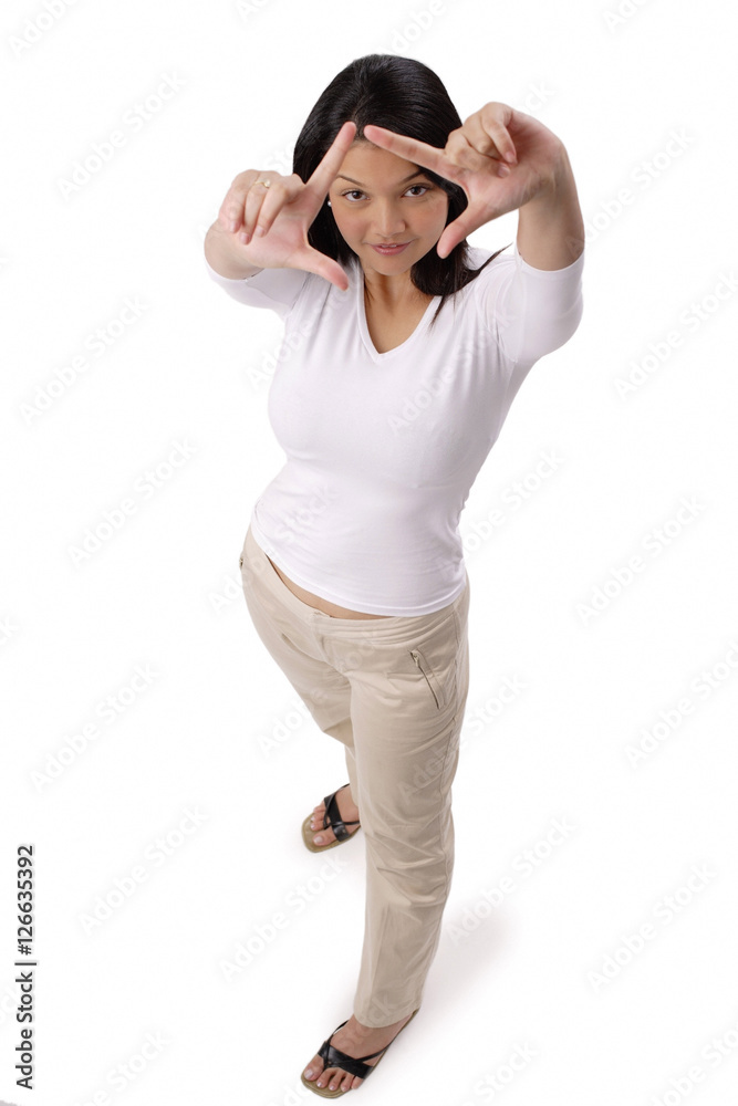 Fototapeta premium Woman looking at camera through finger frame