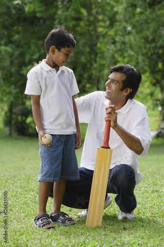 Obraz na płótnie A father and son play cricket together w salonie