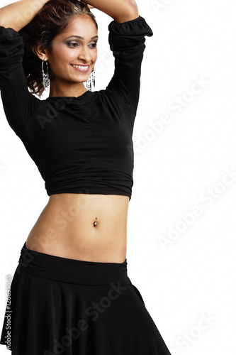 Woman standing with hands on head, looking away