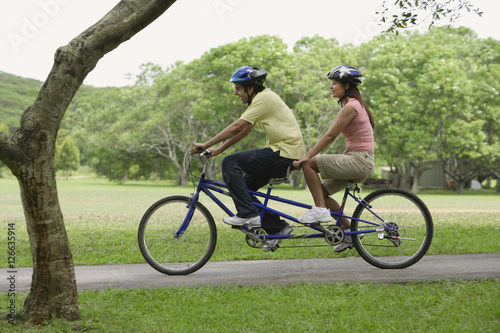 A couple ride a bike together