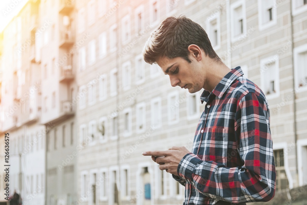 Fototapeta premium young man with mobile phone in the city