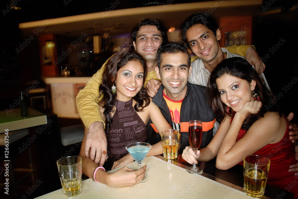 Young adults in club, smiling at camera