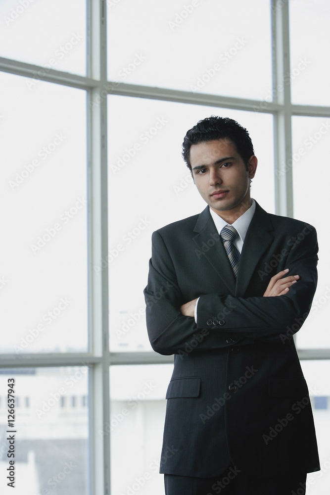Young businessman arms crossed, looking at camera Young businessman arms crossed, looking at camera