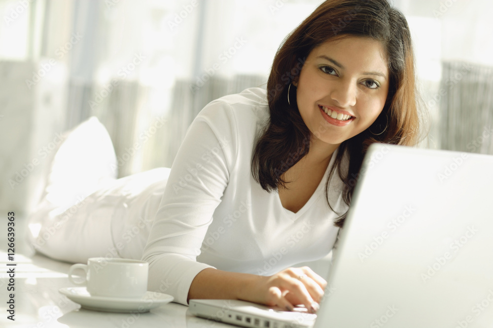 Woman at home with laptop, smiling at camera Woman at home with laptop, smiling at camera