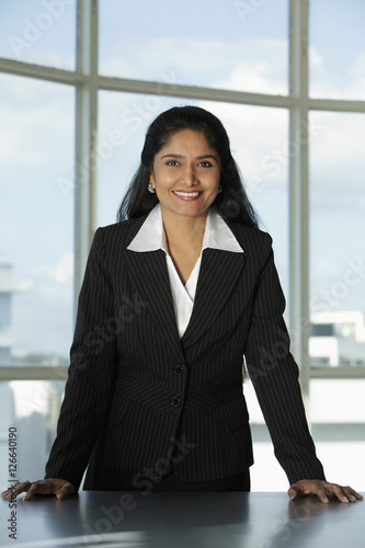 Indian woman standing at her desk