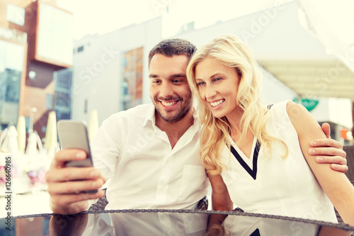 couple taking selfie with smatphone at restaurant