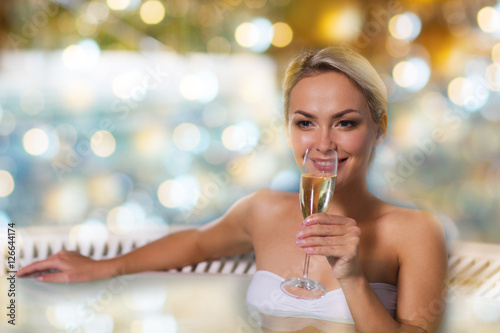 happy woman drinking champagne at swimming pool