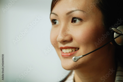 Young woman wearing hands-free device  smiling