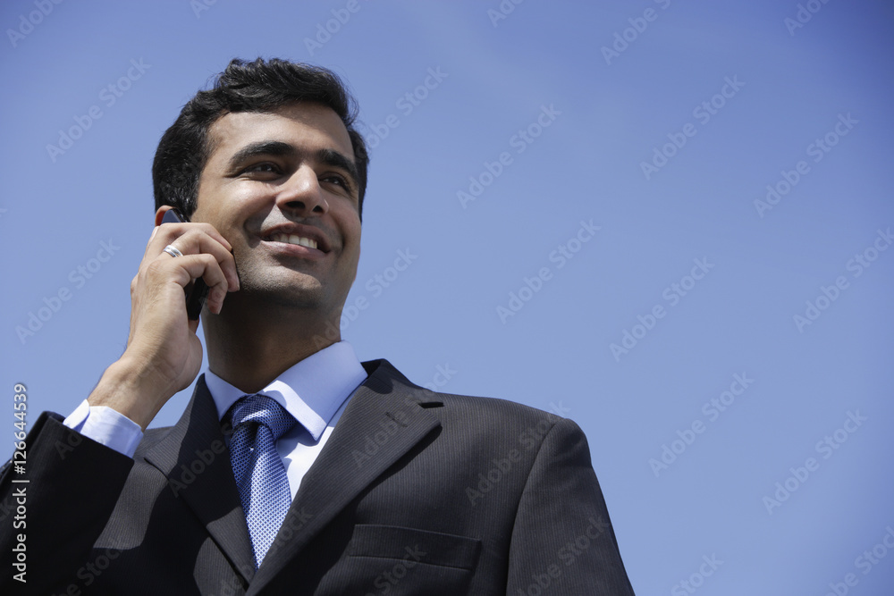 Indian businessman talking on phone outside. Indian businessman talking on phone outside.