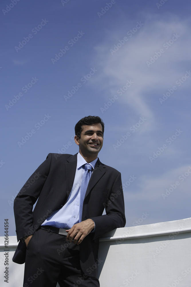 Indian businessman leaning on balcony. Indian businessman leaning on balcony.