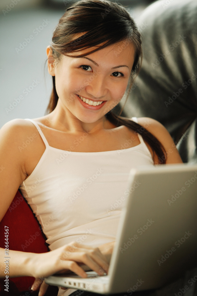 Young woman on sofa, looking at camera, smiling Young woman on sofa, looking at camera, smiling