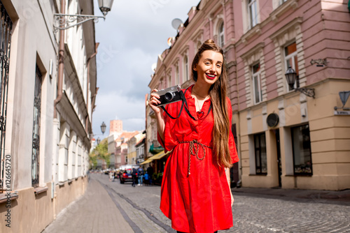 Portrait of a young female tourist with photo camera on the main pedestrian street in the old town of Vilnius. Woman having great vacations in lithuania © rh2010