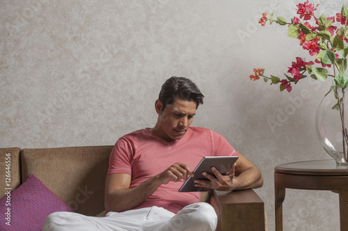 Photography India, Man sitting on sofa using digital tablet