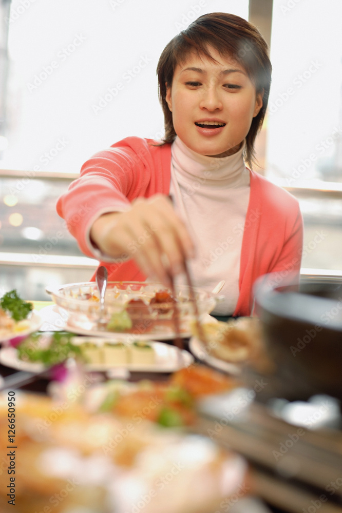 Young woman at a Chinese restaurant, eating