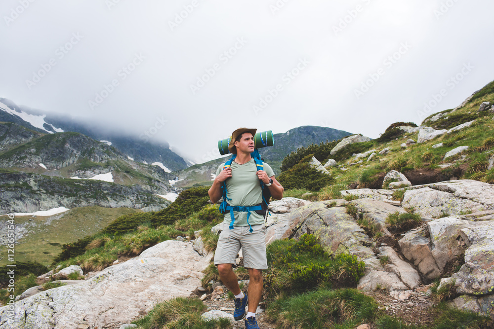 Young man with backpack in the mountain