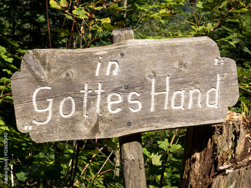 Schild mit Aufschrift in Gottes Hand