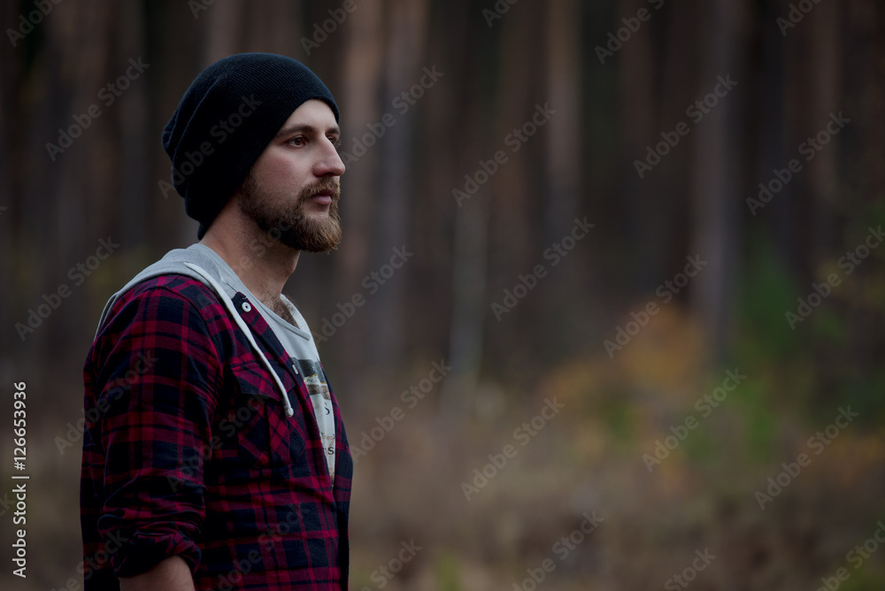 Portrait brutal bearded hipster man in the forest