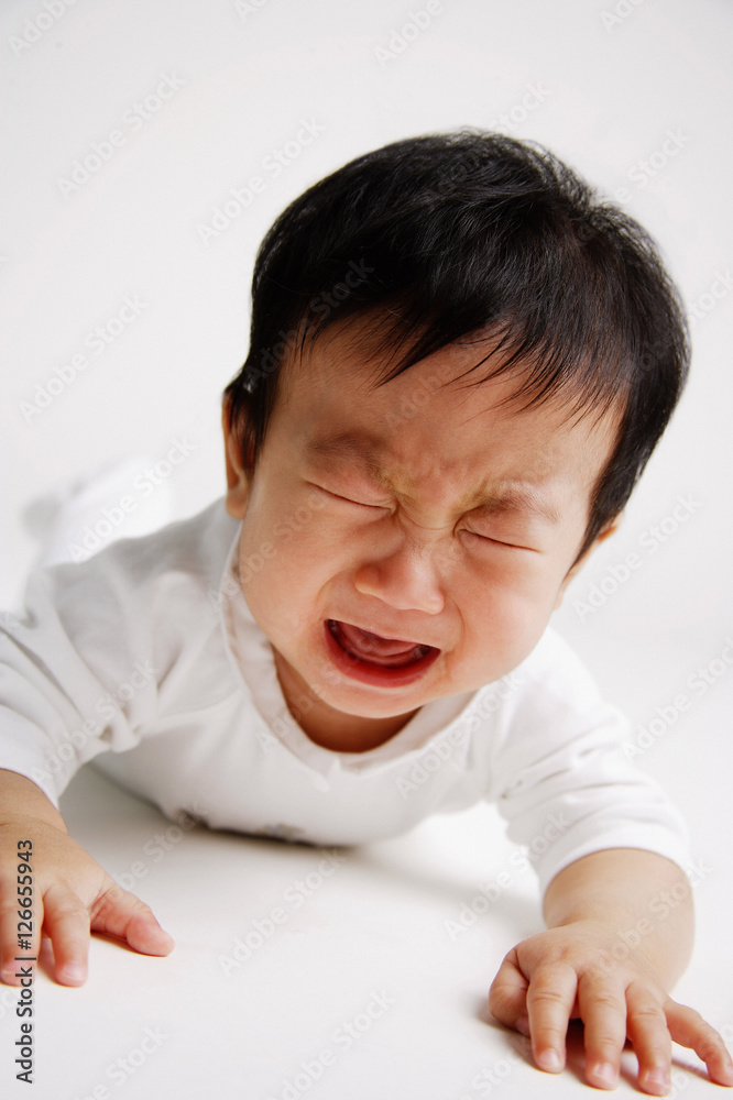 Baby boy lying on front, crying Baby boy lying on front, crying