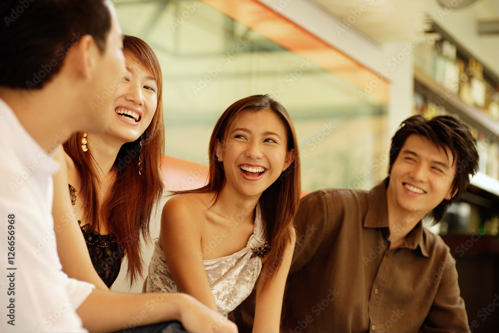Fototapeta premium Young adults sitting together, smiling