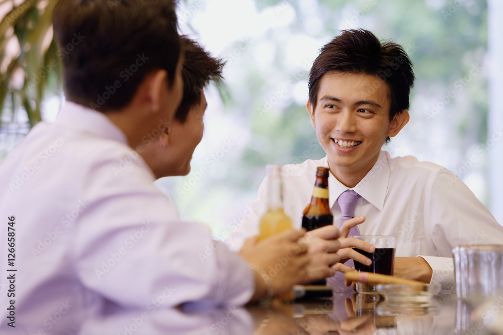Young men at bar counter with drinks Young men at bar counter with drinks