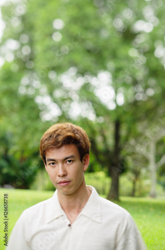 Man outdoors, looking at camera, head shot