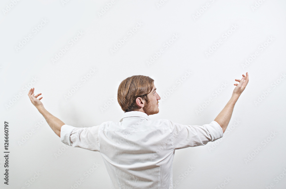 Young Adult Male in White Shirt Gesturing Arms Raised, Wide Open Young Adult Male in White Shirt Gesturing Arms Raised, Wide Open