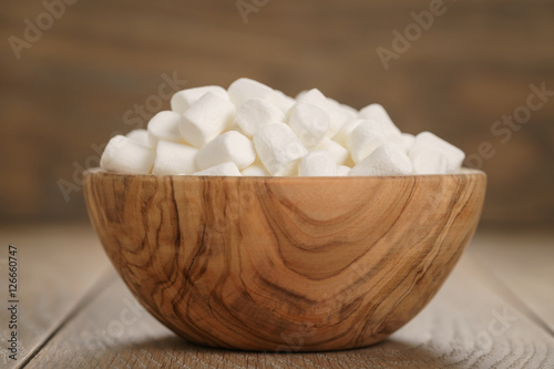 white marshmallows in wooden bowl on table