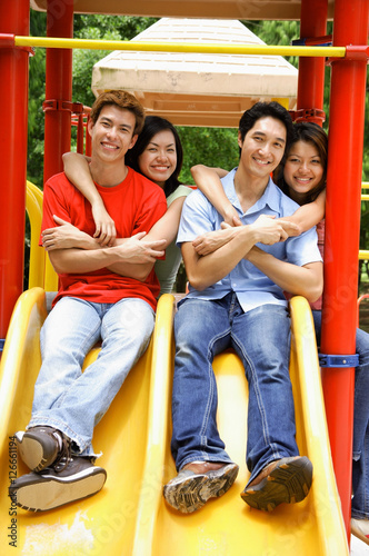 Young adults in playground, smiling at camera, portrait