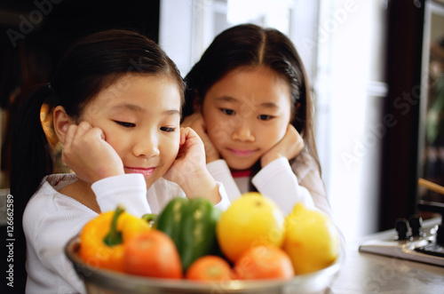 Children staring at a bowl of vegetables