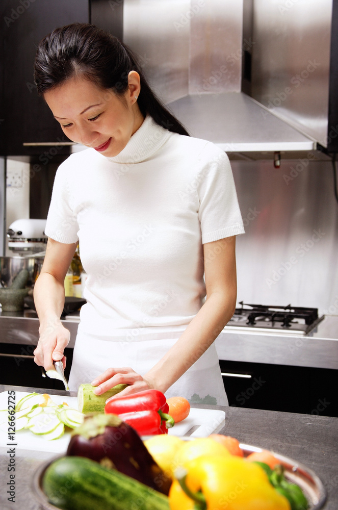 Woman cutting vegetables, smiling