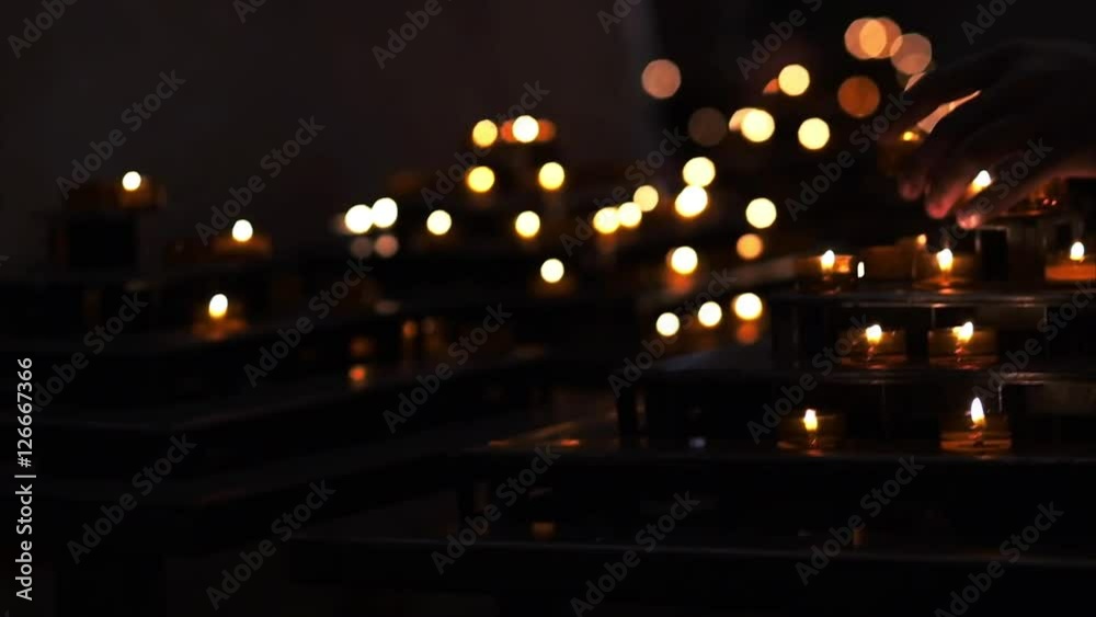 The man prays near burning candles on candleholder in the cathedral. Candlelight, sorrow, memory, religion. Real time video. The man prays near burning candles on candleholder in the cathedral. Candlelight, sorrow, memory, religion. Real time video.