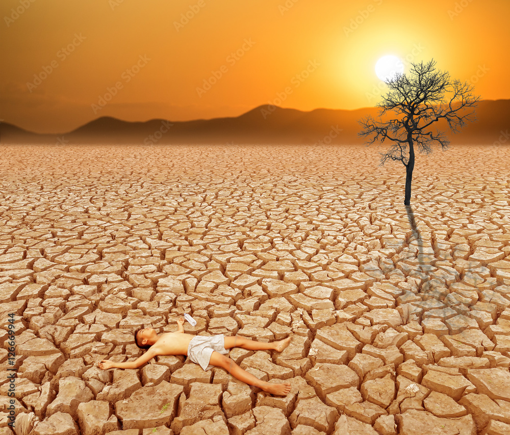 Child lying on cracked earth in the arid area