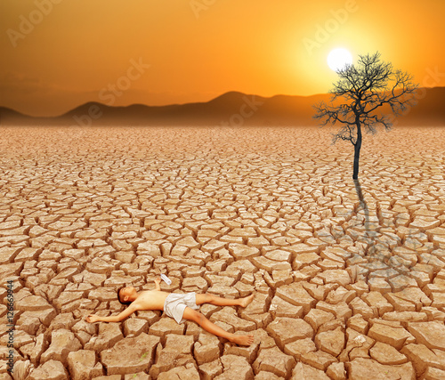 Child lying on cracked earth in the arid area © ittipol